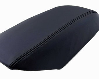 May include: Black leather center console armrest cover with a stitched seam down the center.