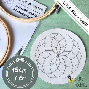 May include: A white embroidery hoop with a black geometric design printed on it. The hoop is 6 inches in diameter and is labeled "Stick, Sew + Wash".
