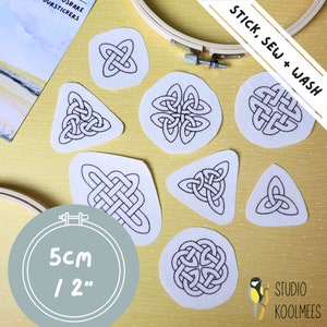 Peut inclure: Huit cercles et triangles en feutre blanc avec des motifs de nœuds celtiques noirs, chacun mesurant 5 cm ou 2 pouces. Le texte "STICK, SEW + WASH" est écrit en noir sur un fond jaune. Le texte "5CM / 2" est écrit en noir sur un cercle gris. Un petit oiseau se trouve dans le coin inférieur droit.