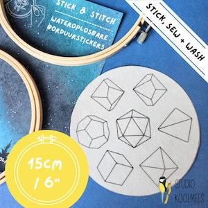 Op de afbeelding: Een witte, ronde borduurring met zes geometrische vormen geborduurd in zwarte draad. De ring heeft een diameter van 15 cm en bevindt zich op een blauwe achtergrond. De tekst "STICK, SEW + WASH" staat in een wit rechthoek op de blauwe achtergrond. De tekst "STICK & STITCH" staat op een witte kaart met de tekst "WATEROPLOSBARE BORDUURSTICKERS" eronder.