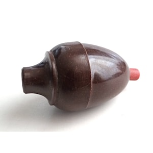 May include: A brown ceramic light switch with a red tip.