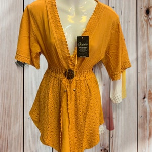 Pode incluir: Um vestido de croch&ecirc; amarelo mostarda com acabamento em renda e fecho de bot&atilde;o no decote. O vestido tem um corpete justo e uma saia fluida. O vestido &eacute; feito de um tecido leve e &eacute; perfeito para o clima quente.