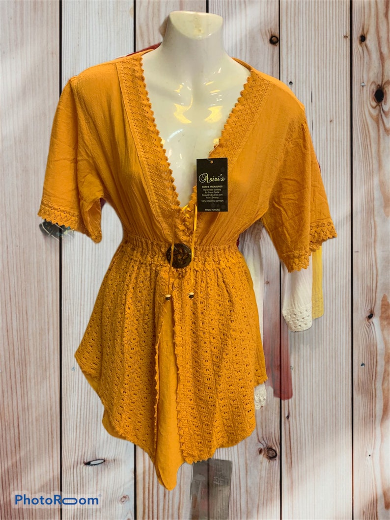 Pode incluir: Um vestido de croch&ecirc; amarelo mostarda com acabamento em renda e fecho de bot&atilde;o no decote. O vestido tem um corpete justo e uma saia fluida. O vestido &eacute; feito de um tecido leve e &eacute; perfeito para o clima quente.