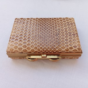 Peut inclure: Une petite boîte rectangulaire en peau de serpent marron avec un fermoir en métal doré.