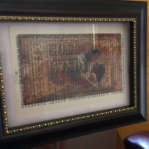 May include: A framed print with a vintage aesthetic featuring a collage of text and images. The text includes the words "Gone With The Wind" and "The Battle of the Boyne". The image is a sepia-toned portrait of a couple.