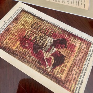 May include: A vintage-style postcard with a red, white, and gold design. The postcard features the words "Gone With The Wind" in a bold, decorative font. The background is a collage of old text and images.