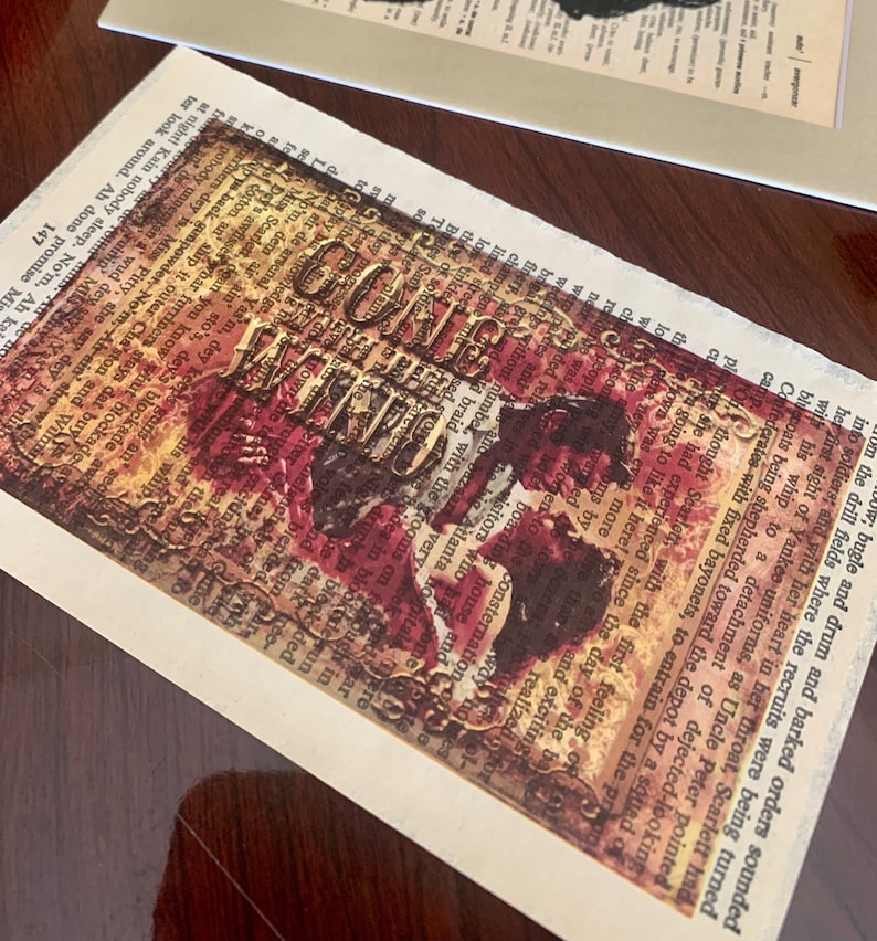 May include: A vintage-style postcard with a red, white, and gold design. The postcard features the words "Gone With The Wind" in a bold, decorative font. The background is a collage of old text and images.