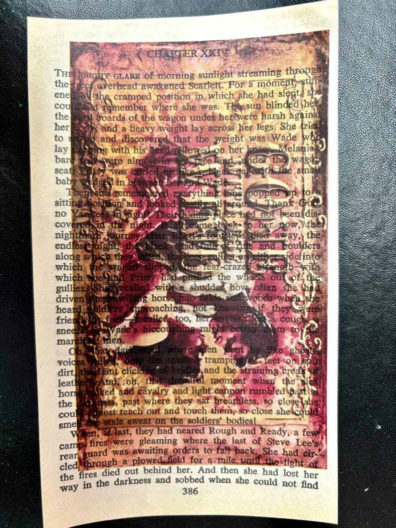 May include: A vintage book page with a red, orange, and yellow paint splatter effect. The text on the page is from a novel titled "Gone With The Wind" by Margaret Mitchell. The text reads "CHAPTER XXIV" and "The bright glare of morning sunlight streaming through the overhead awakened Scarlett. For a moment, still in the cramped position in which she had slept, she could not remember where she was. The sun blinded her and a heavy weight lay across her legs. She tried to move and discovered that the weight was Wade who was sleeping with his head plowed on her knees. Melanie was almost in hot face and under the wagon seat, Prissy was curled up like a block of ice with the small baby wedged in between her and Wade."