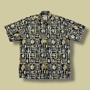 May include: Short-sleeved button-down shirt with a repeating geometric pattern of leaves and rectangles in black, white, and gold. The shirt has a collared neckline and a relaxed fit.