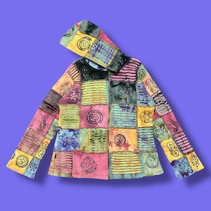 May include: A colorful patchwork hoodie with a zip-up front and hood. The jacket features a variety of square patches in shades of pink, yellow, blue, and green, adorned with various designs. The hoodie is a vibrant and unique piece of clothing.