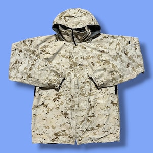 Könnte beinhalten: Eine langärmelige Kapuzenjacke mit einem digitalen Tarnmuster in Beige-, Sand- und Brauntönen. Die Jacke verfügt über einen hohen Kragen, einen Frontreißverschluss und elastische Ärmelbündchen. Die Kapuze ist in den Kragenbereich integriert.