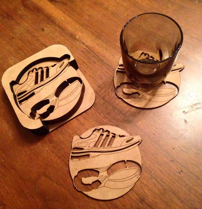 May include: Three wooden coasters featuring a laser-cut design of a running shoe. The coasters are circular and square in shape.