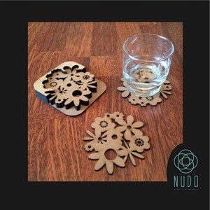 May include: Set of three brown wooden coasters with a floral design. The coasters are laser cut and have a delicate, intricate pattern. The coasters are perfect for protecting your furniture from scratches and spills.