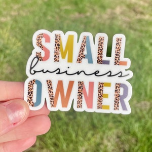 May include: A sticker with the text "SMALL business OWNER" in colorful letters with a leopard print pattern.