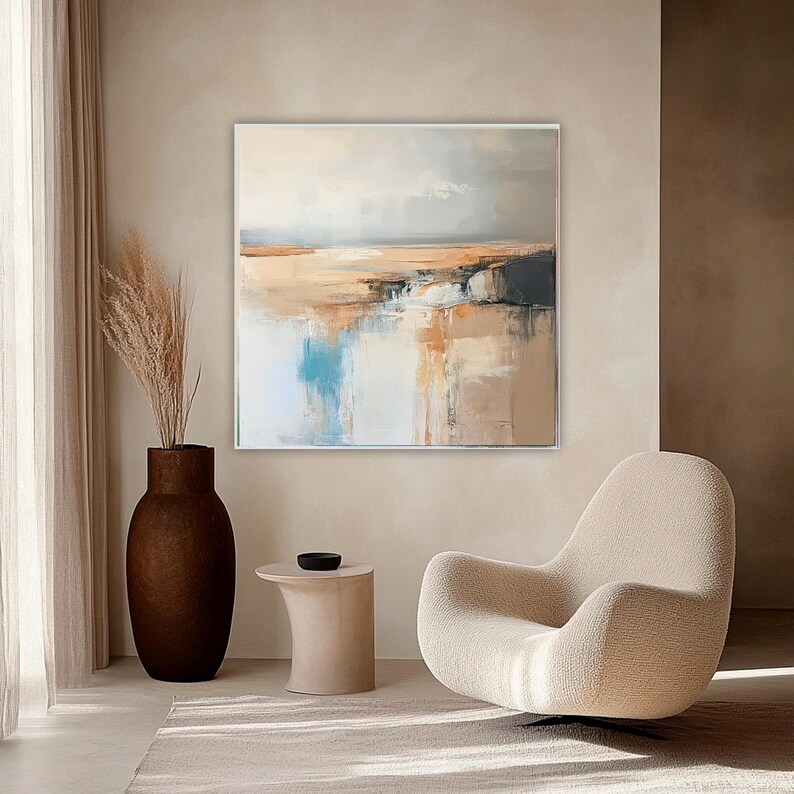 May include: Abstract landscape painting with a neutral color palette. The artwork features a blend of beige, brown, blue, and gray tones, creating a serene and modern aesthetic. The painting is displayed in a bright, airy room with a modern chair and a decorative vase.