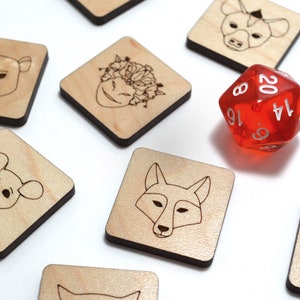 May include: A red twenty-sided die with white numbers sits on a white surface surrounded by wooden tiles with black borders. Each tile features a different animal illustration, including a bear, a fox, a mouse, a monkey, a hyena, a devil, and a person with a flower crown.