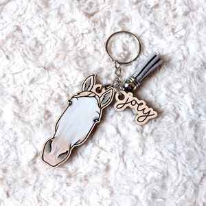 May include: A wooden horse head keychain with a gray tassel and a wooden tag that says "Joey".