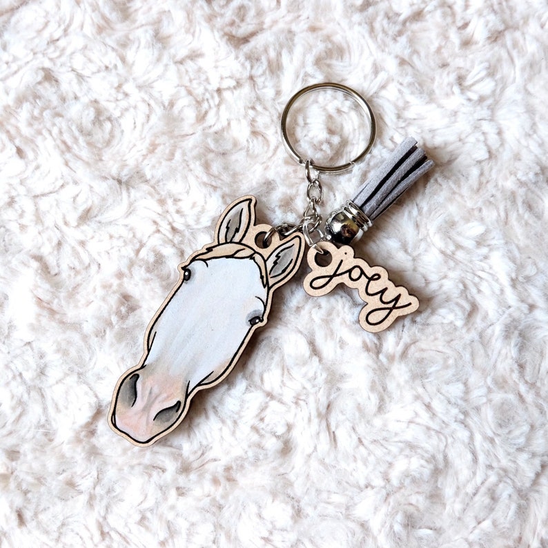 May include: A wooden horse head keychain with a gray tassel and a wooden tag that says "Joey".