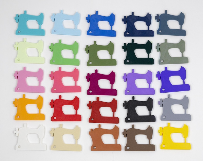 May include: A collection of colorful sewing machine cutouts in various shades, including blue, green, pink, red, orange, and yellow. The sewing machines are arranged in a grid pattern against a white background, showcasing a variety of hues.