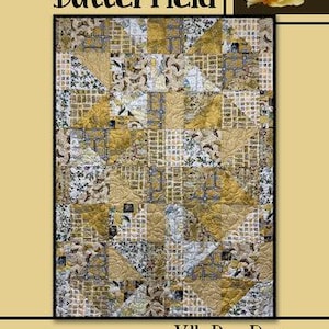 May include: A quilt with a patchwork design in shades of gold, cream, and gray. The quilt features a variety of patterns, including floral prints and geometric shapes. The word "Butterfield" is at the top, and "Villa Rosa Designs" is at the bottom.