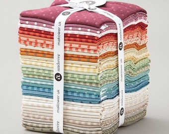 May include: A stack of folded fabric squares in a gradient of colors including burgundy, red, orange, yellow, green, blue, and beige. Each piece features a small white polka dot pattern. The stack is secured with a white ribbon labeled makower uk.