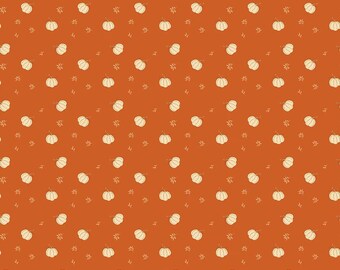 May include: A fabric swatch featuring a repeating pattern of small, cream-colored pumpkins and tiny leaf sprigs scattered across a solid burnt orange background. A white ruler measuring 12 inches is visible along the bottom edge of the fabric.