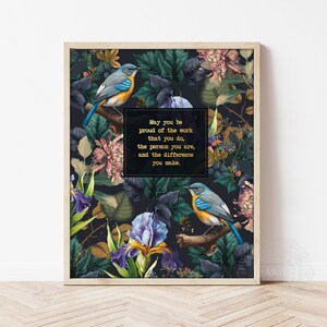 May include: A framed art print with a dark floral design, showcasing blue and orange birds. The print includes the text: "May you be proud of the work that you do, the person you are, and the difference you make."