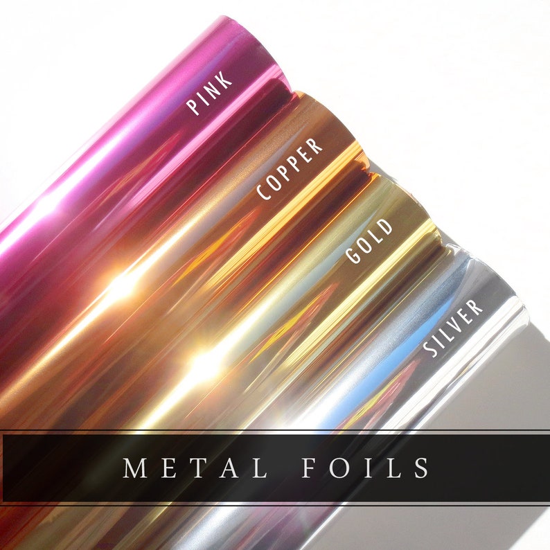 May include: A close-up of rolls of metal foils in pink, copper, gold, and silver. The word "PINK" is printed on the pink foil, "COPPER" on the copper foil, "GOLD" on the gold foil, and "SILVER" on the silver foil. The text "METAL FOILS" is printed on a black bar.