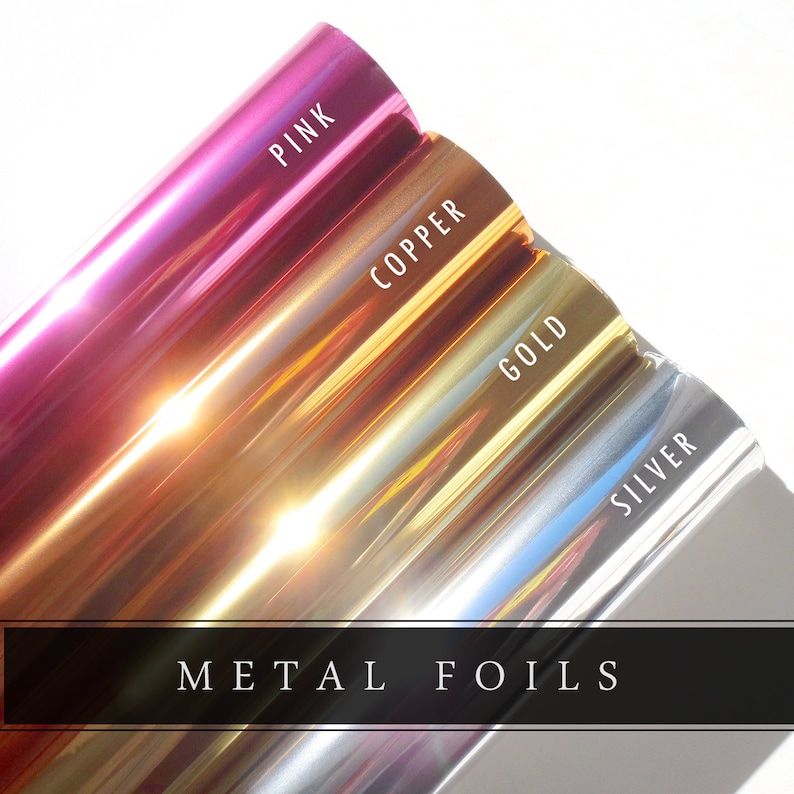 Puede incluir: Cuatro rollos de l&aacute;mina met&aacute;lica en rosa, cobre, oro y plata. Los rollos est&aacute;n etiquetados con el nombre del color. El texto "METAL FOILS" est&aacute; impreso debajo de los rollos.