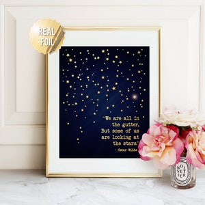 May include: A navy blue printable art print with gold foil stars and a quote by Oscar Wilde: "We are all in the gutter, But some of us are looking at the stars."