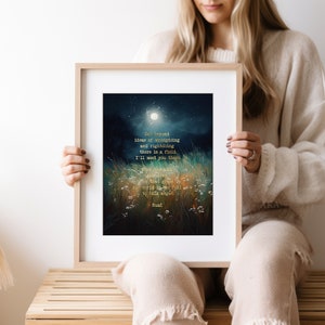 May include: A framed print with a dark blue and green watercolour background featuring a moon and a field of grass. The print includes a poem in gold lettering that reads: "Out beyond ideas of wrongdoing and rightdoing there is a field. I'll meet you there. When the soul finds that grass the world is too full to talk about. -Rumi"