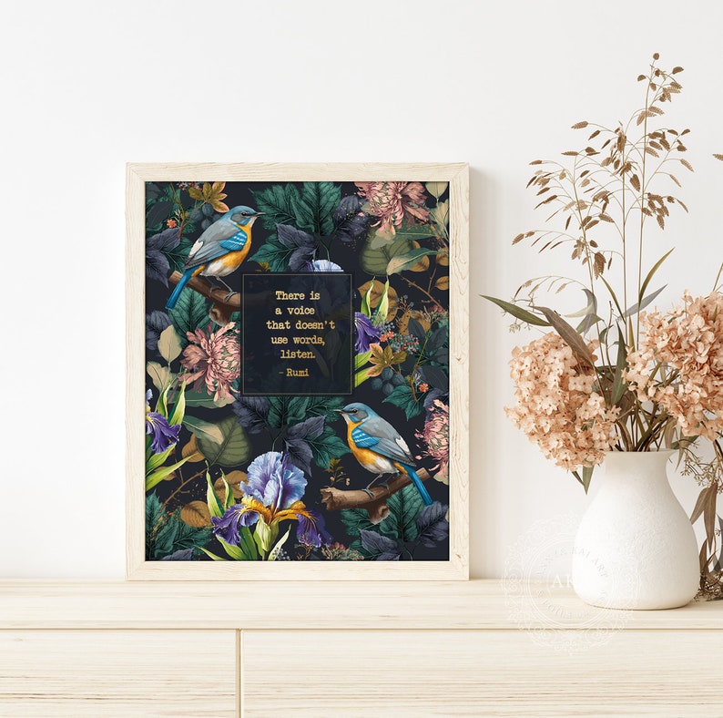 May include: A framed print with a dark background featuring a floral pattern with two blue birds perched on branches. The quote "There is a voice that doesn't use words, listen." - Rumi is printed in gold lettering on the print.