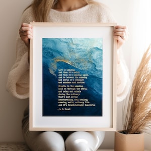 May include: A framed wall art print featuring a deep blue and white abstract watercolor background with gold flecks. The text reads: Life is amazing. And then it's awful. And then it's amazing again. And in between the amazing and awful it's ordinary and mundane and routine. Breathe in the amazing, hold on through the awful, and relax and exhale during the ordinary. That's just living heartbreaking, soul-healing, amazing, awful, ordinary life. And it's breathtakingly beautiful. - L. R. Knost