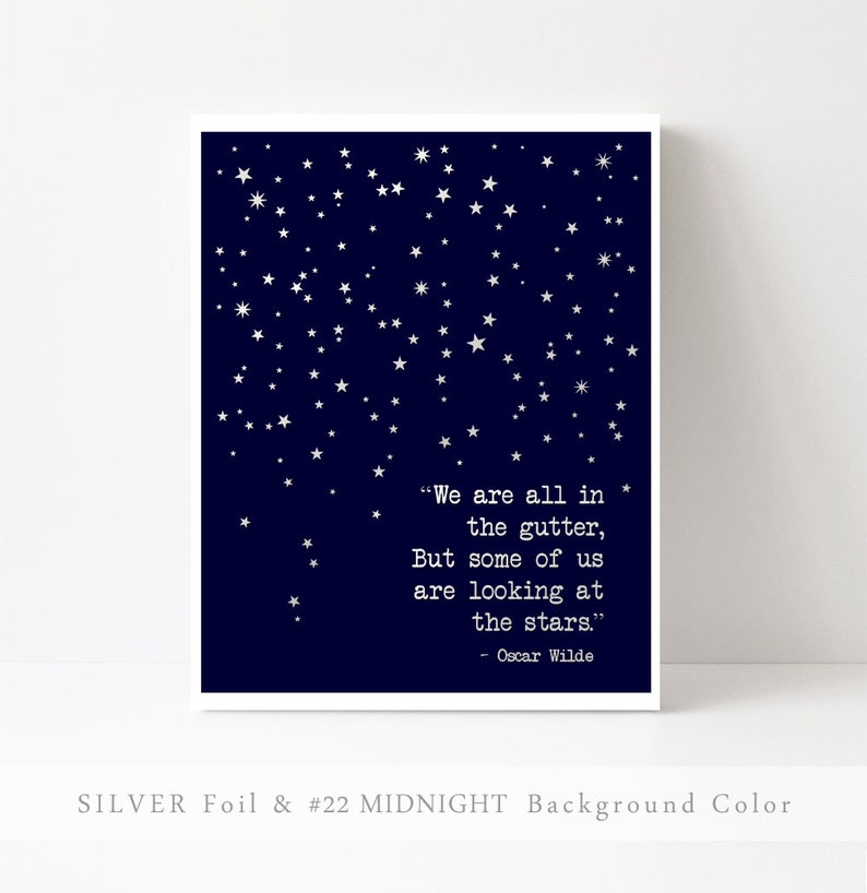 May include: A navy blue printable art print with silver foil stars and a quote by Oscar Wilde: "We are all in the gutter, but some of us are looking at the stars."