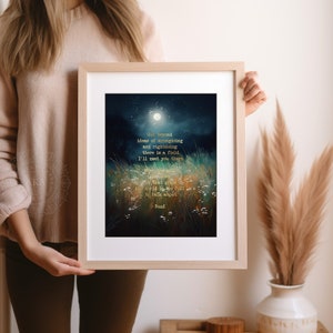May include: A framed print with a dark blue background and a moon in the sky. The print features a quote by Rumi in gold lettering: "Out beyond ideas of wrongdoing and rightdoing there is a field. I'll meet you there." The quote is surrounded by a field of tall grass and wildflowers.