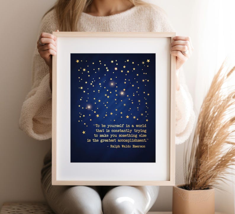 May include: A blue and gold printable wall art print with a quote by Ralph Waldo Emerson: "To be yourself in a world that is constantly trying to make you something else is the greatest accomplishment."