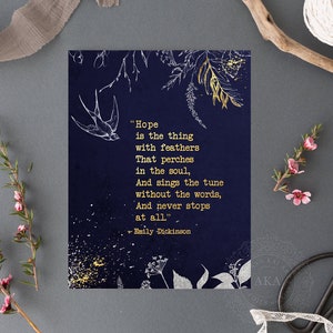 May include: A navy blue card with gold lettering featuring a quote by Emily Dickinson about hope. The quote reads "Hope is the thing with feathers That perches in the soul, And sings the tune without the words, And never stops at all." The card is decorated with gold and white floral illustrations.