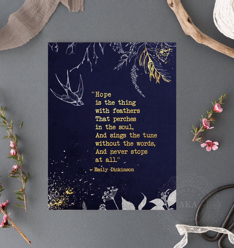 May include: A navy blue card with gold lettering featuring a quote by Emily Dickinson about hope. The quote reads "Hope is the thing with feathers That perches in the soul, And sings the tune without the words, And never stops at all." The card is decorated with gold and white floral illustrations.
