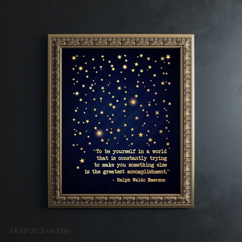May include: A navy blue printable art print with gold foil stars and a quote by Ralph Waldo Emerson: "To be yourself in a world that is constantly trying to make you something else is the greatest accomplishment."