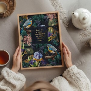 May include: A framed print with a dark background featuring a floral design with two blue birds. The quote "There is a voice that doesn't use words, listen." by Rumi is printed in gold lettering on the print.