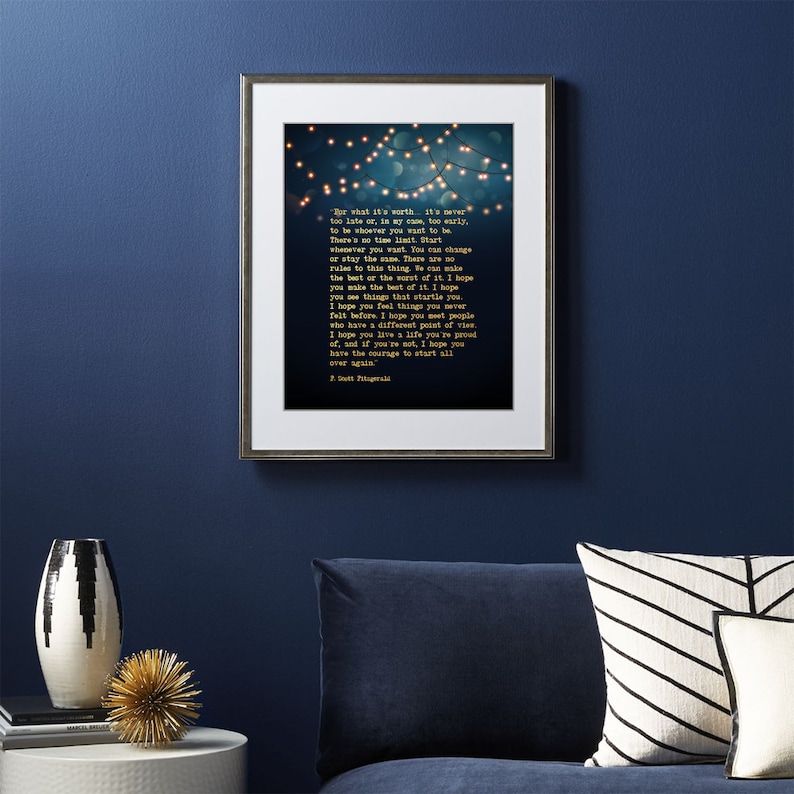 May include: A framed print with a blue background and gold text. The text is a quote by F. Scott Fitzgerald that reads: "For what it's worth, it's never too late or, in my case, too early, to be whoever you want to be. There's no time limit. Start whenever you want. You can change or stay the same. There are no rules to this thing. We can make the best of the worst of it. I hope you make the best of it. I hope you see things that startle you. I hope you feel things you never felt before. I hope you meet people who have a different point of view. I hope you live a life you're proud of, and if you're not, I hope you have the courage to start all over again."