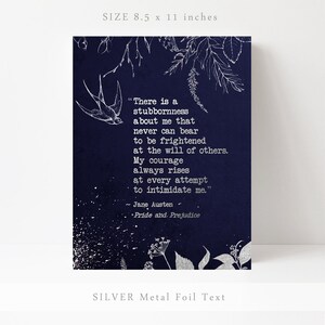 May include: A navy blue print with silver foil text featuring a quote from Jane Austen's "Pride and Prejudice": "There is a stubbornness about me that never can bear to be frightened at the will of others. My courage always rises at every attempt to intimidate me."