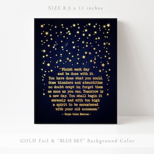 May include: Gold foil print on a dark blue background with a quote by Ralph Waldo Emerson about finishing each day. The quote is surrounded by gold stars. The print measures 8.5 by 11 inches.