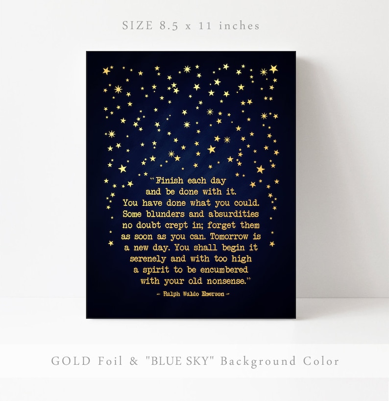 May include: Gold foil print on a dark blue background with a quote by Ralph Waldo Emerson about finishing each day. The quote is surrounded by gold stars. The print measures 8.5 by 11 inches.