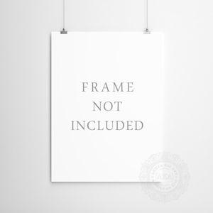 May include: A white poster with the text "FRAME NOT INCLUDED" printed in gray. The poster is hanging on a white wall with two silver clips.