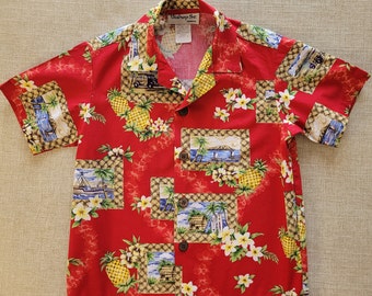 Puede incluir: Camisa roja de manga corta con botones y estampado tropical con palmeras, flores y tablas de surf. La camisa tiene una etiqueta tejida que dice "Bishop St. Apparel".
