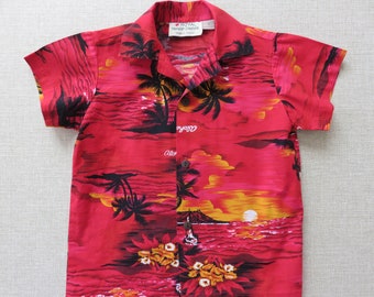 Puede incluir: Camisa hawaiana de manga corta roja con estampado de puesta de sol y palmeras. La camisa tiene un frente abotonado y un cuello. La etiqueta dice "Royal Hawaiian Creations".