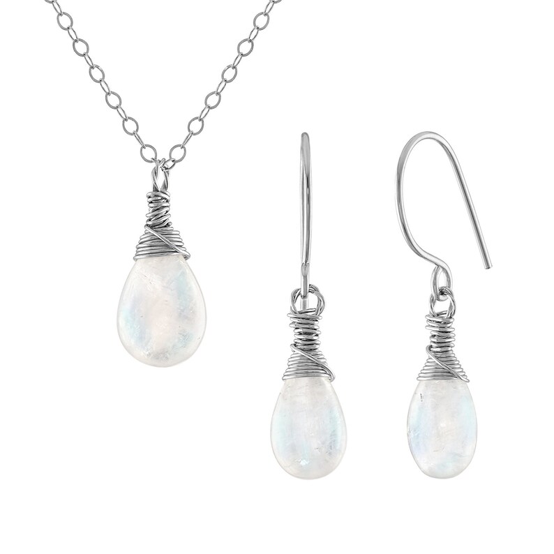 Puede incluir: Un conjunto de collar y pendientes de plata con un colgante de piedra lunar en forma de l&aacute;grima y pendientes a juego. Las piedras est&aacute;n envueltas en alambre de plata.