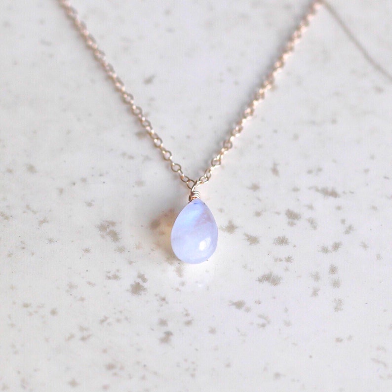 Puede incluir: Un delicado collar de cadena de plata con un colgante de piedra lunar en forma de l&aacute;grima.