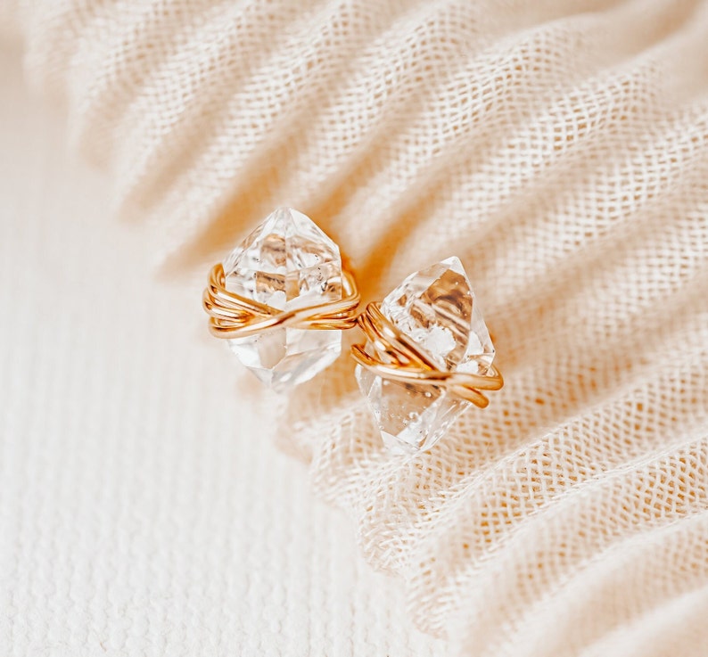 Herkimer Diamond Stud Earrings. Quartz crystals wrapped three times in gold wire for completed post earrings. The quartz crystals are transparent, colorless, and naturally faceted. They are double-terminated crystals (pointed on both ends).